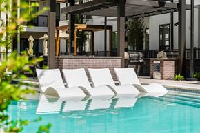 Plano apartment for rent - A pool with a white sunbed in the middle of it.