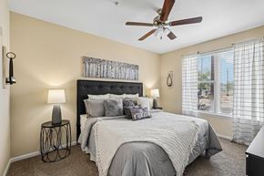 Peoria apartment for rent - A bedroom with a large bed and a ceiling fan.