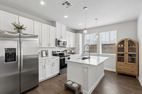 Fort Worth apartment for rent - A modern kitchen with a stainless steel refrigerator and white cabinets.