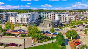 Oak Creek apartment for rent - A view of a city with apartment buildings, trees, and a parking lot.