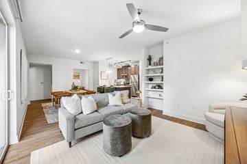 Plano apartment for rent - A living room with a grey couch and a grey ottoman.