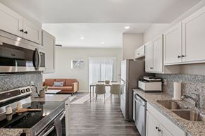 Blue Springs apartment for rent - A modern kitchen with a black stove top oven and a marble counter top.