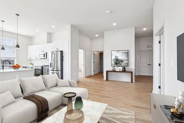 Metuchen apartment for rent - A modern living room with a white sofa and a wooden coffee table.