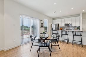 Fulshear apartment for rent - A modern kitchen with a dining table and chairs.