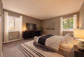Birmingham apartment for rent - A bedroom with a bed, a dresser, and a window with curtains.