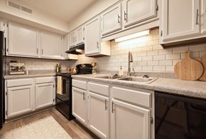 Birmingham apartment for rent - A kitchen with white cabinets and a black oven.