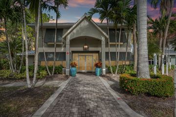 Naples apartment for rent - A building with a red cross on the front door is surrounded by palm trees.