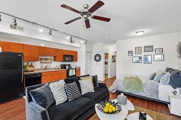 Peoria apartment for rent - A black refrigerator is in a kitchen with wooden cabinets.
