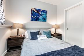 Kansas City apartment for rent - a bedroom with a bed with blue pillows and a painting on the wall