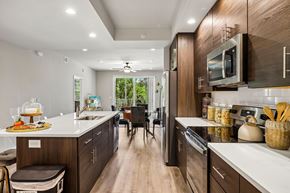 Fort Myers apartment for rent - A modern kitchen with dark wood cabinets and white countertops.