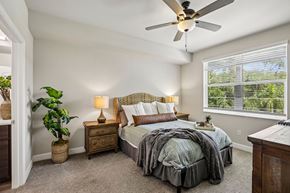 Fort Myers apartment for rent - A bedroom with a bed, nightstand, and a ceiling fan.