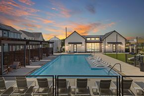 San Antonio apartment for rent - a swimming pool with chairs around it at sunset