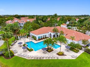 Doral apartment for rent - A large house with a pool in the middle of a grassy area.