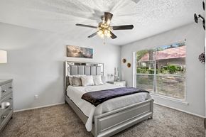 Tyler apartment for rent - A bedroom with a large bed and a ceiling fan.