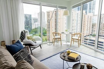 Atlanta apartment for rent - A living room with a couch, chairs, and a coffee table with a book on it.