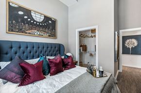 Nashville apartment for rent - Three-Bedroom Apartments in
Germantown, Nashville, TN -
Peyton Stakes - Furnished
Bedroom with Hardwood-Inspired
Flooring, Large Bed, Nightstand
with Lamp, Framed Wall Art, and
Spacious Closet with Shelves.