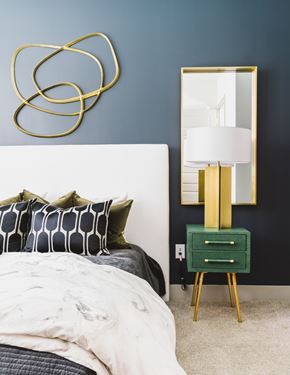 Atlanta apartment for rent - A bedroom with a bed, a nightstand with a lamp, and a mirror.