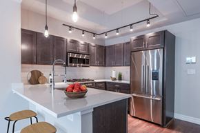Albany apartment for rent - A modern kitchen with a stainless steel refrigerator and wooden bar stools.