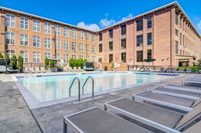 Menands apartment for rent - A large swimming pool in front of a brick building.