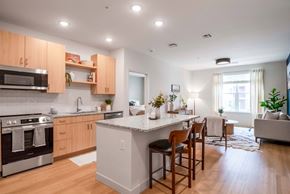 Chelmsford apartment for rent - A modern kitchen with wooden cabinets and a white island.