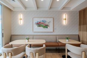 Peabody apartment for rent - A dining area with a floral picture on the wall and a bench seating two people.