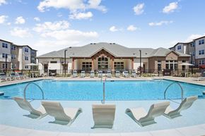 Fairburn apartment for rent - a swimming pool with chairs in front of an apartment building
