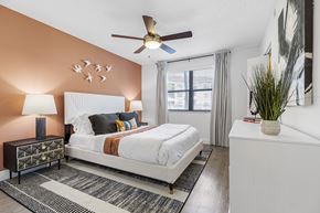 Hollywood apartment for rent - A bedroom with a white bed and a ceiling fan.