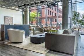 Chicago apartment for rent - A modern living room with a grey sofa, a black and white chair, and a wooden coffee table.