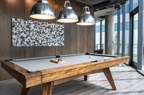 Chicago apartment for rent - A pool table with a wooden frame and a green felt cloth is in the foreground of the image.
