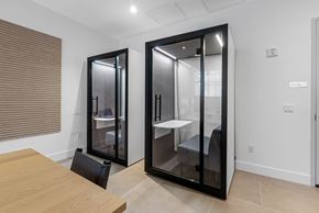 Miami apartment for rent - A modern kitchen with a wooden table and black fridge.