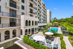 Miami apartment for rent - A large white building with a pool in front.