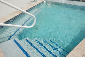 Raymore apartment for rent - Two-Bedroom Townhomes in Raymore, MO - Ascend - Fenced Outdoor Swimming Pool With Wide Entry Steps And Poolside Handrail On Concrete Sundeck.