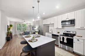 Charleston apartment for rent - an open kitchen and dining room with white cabinets and stainless steel appliances