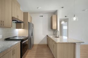 Bryan apartment for rent - A kitchen with wooden cabinets and a granite countertop.