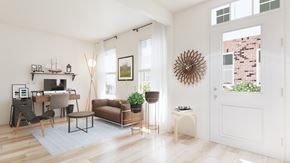 Waldorf apartment for rent - A living room with a brown couch, a chair, a table, a plant, and a clock on the wall.