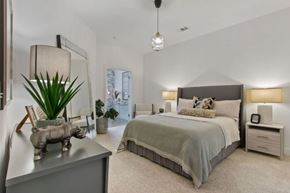 Camp Springs apartment for rent - A bedroom with a large bed and a piggy bank on the dresser.