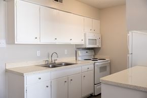 San Antonio apartment for rent - A kitchen with white cabinets and appliances.
