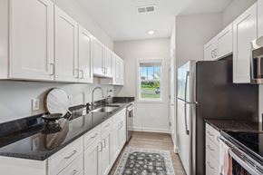Nashville apartment for rent - a white kitchen with white cabinets and black counter tops