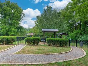 Asheville apartment for rent - A small pavilion is surrounded by a hedge and a gravel path.