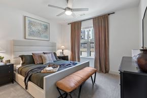 Fort Worth apartment for rent - bedroom with a large bed and a ceiling fan