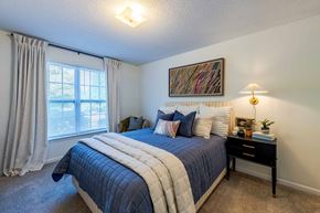 Knightdale apartment for rent - A bedroom with a large bed and a window with curtains.