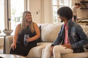 Conyers apartment for rent - A man and a woman are sitting on a couch, the woman is holding a blue cup.