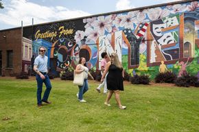 Conyers apartment for rent - A group of people are standing in front of a mural with the words "Celebrations from" written on it.