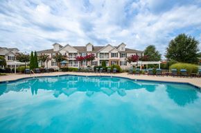 Winston Salem apartment for rent - A large swimming pool in front of a resort-style building.