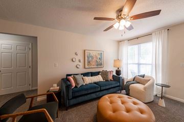 Winston Salem apartment for rent - A living room with a blue couch and a brown ottoman.