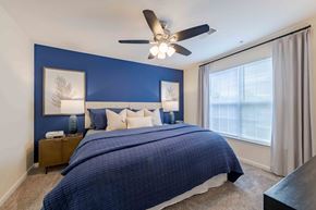 Fayetteville apartment for rent - A bedroom with a bed, nightstands, and a ceiling fan.