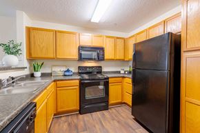 Fayetteville apartment for rent - A kitchen with wooden cabinets and black appliances.
