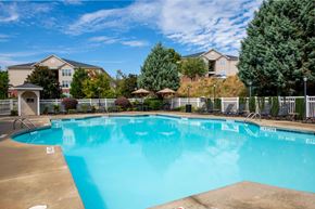 Fayetteville apartment for rent - A large swimming pool in front of a building with a fence around it.