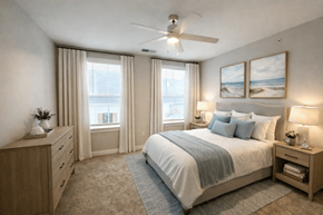 Zionsville apartment for rent - A bedroom with a large bed, a dresser, and a window with curtains.