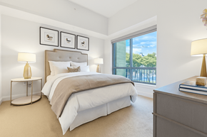 Dallas apartment for rent - A bedroom with a large bed and a view of the outside.